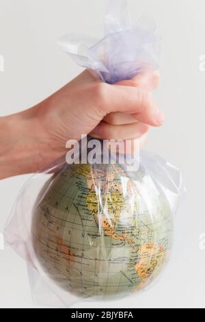 Hand holding earth globe in plastic bag Stock Photo