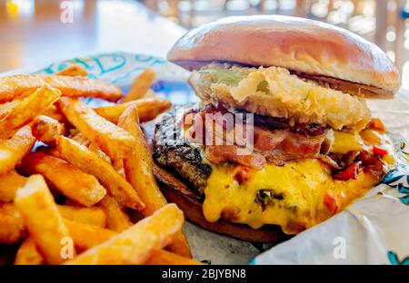 The Pa-Menna cheeseburger, with pimiento cheese, bacon, and fried green tomatoes, is served at Lulu’s Sunset Grill in Gulf Shores, Alabama. Stock Photo
