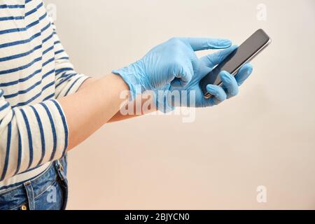 Woman wearing surgical gloves using smart phoneÂ Stock Photo