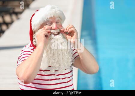 Santa Claus near swimming pool at resort Stock Photo