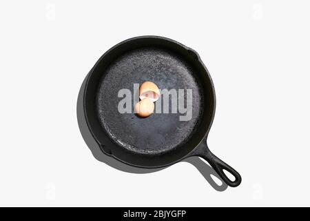 Overhead view of egg shells on frying pan on white background Stock Photo