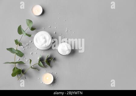 Composition with body cream and candles on grey background Stock Photo