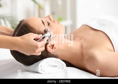 Young woman having facial massage in beauty salon Stock Photo