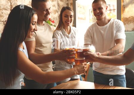 Friends drinking fresh beer in pub Stock Photo