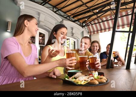 Friends drinking fresh beer in pub Stock Photo