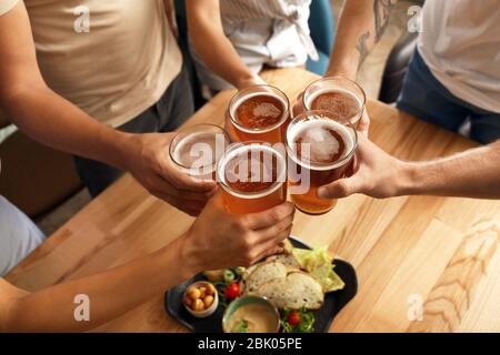 Friends drinking fresh beer in pub Stock Photo
