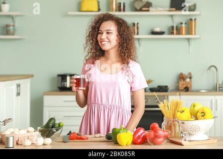 Beautiful African-American woman cooking in kitchen Stock Photo