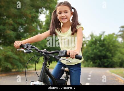 Little girl riding bicycle outdoors Stock Photo