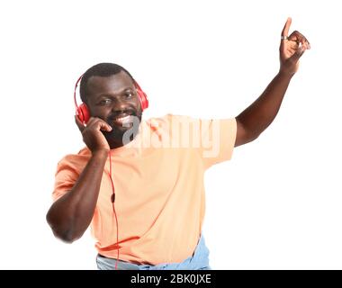 Handsome African-American man listening to music on white background Stock Photo