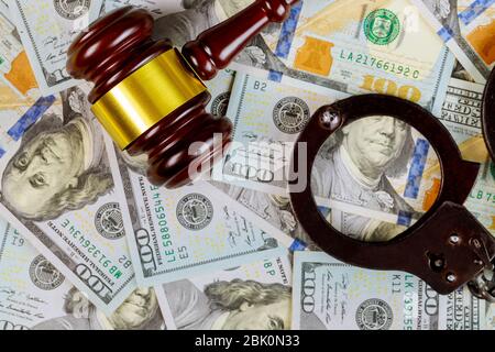 United States dollars bills cash on wooden judge gavel and handcuffs, legal justice desk Stock Photo