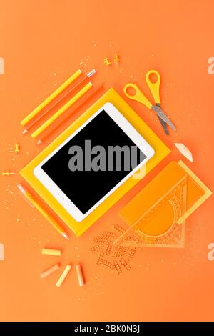 Modern tablet computer and stationery on color background Stock Photo