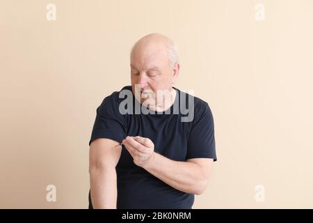 Diabetic man giving himself insulin injection on light background Stock Photo