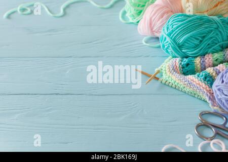 https://l450v.alamy.com/450v/2bk169j/knitted-colored-striped-fabric-yarn-for-knitting-pastel-colors-blue-painted-wood-background-2bk169j.jpg