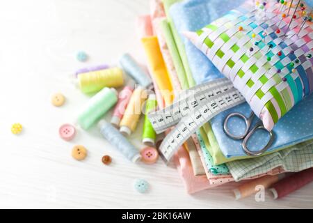 Needle box, threads and cotton fabrics for sewing. White background. Stock Photo