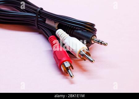 red and white RCA and 3.5 mm audio cable on pink background Stock Photo