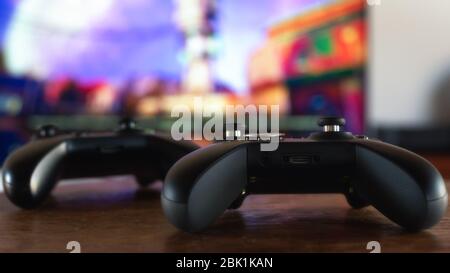 Two gamepad with a video game in background. Video gaming concept. Shallow depth of field image. Stock Photo