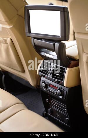 Car inside. Interior in cream colors leather of prestige luxury modern car. Swivel blank white isolated display for back seats passenger with media co Stock Photo
