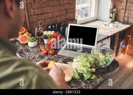 Man in quarantine making a salad at home Stock Photo