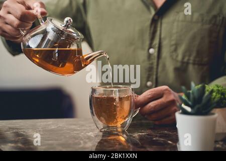 Male brewing a herbal beverage in the kitchen Stock Photo