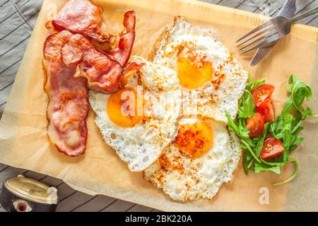 English breakfast with ham and eggs served on a wooden plate. Stock Photo