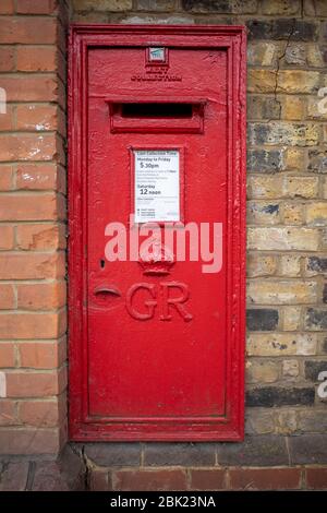 Royal Mail iconic read George V cipher wall mounted post box from the early 20th century Stock Photo