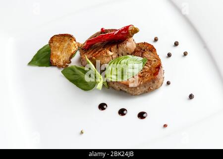 Grilled beaf medallions served on a white plate in a restaurant Stock Photo