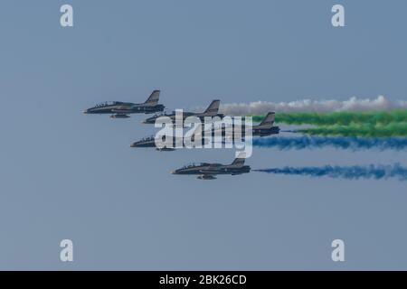 UAE Largest Military Union Fortress 7 Show in Umm al Quwain with coordinated military aircrafts showing the UAE flag colors on the bright blue sky Stock Photo