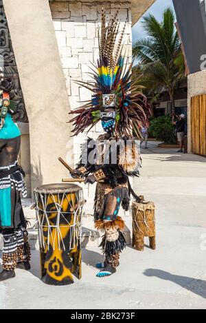 Costa Maya, Mexico - April 25, 2019: Local man in colorful traditional costumes drum and dance to entertain tourists outside the Costa Maya village ma Stock Photo