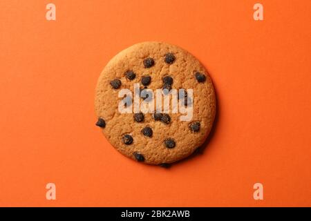 Tasty chocolate chip cookie on orange background Stock Photo
