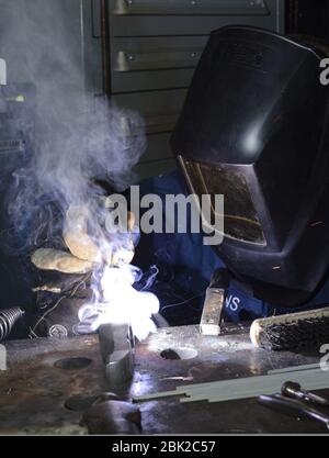 U.S. Navy Hull Maintenance Technician 2nd Class performs a welding procedure in the machine shop aboard the aircraft carrier USS Nimitz (CVN 68) April 10, 2013, in the Pacific Ocean 130410 Stock Photo