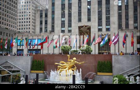 New York, USA – August 23, 2018: The golden Prometheus statue (ancient Greek god Prometheus) at Rockefeller Center with flags in Manhattan, New York, Stock Photo