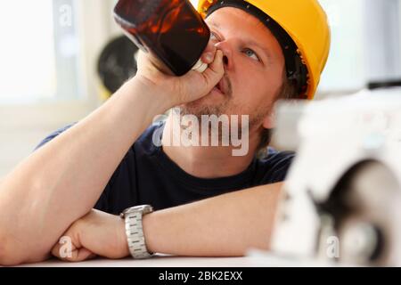 Arm of drunken worker in yellow helmet Stock Photo