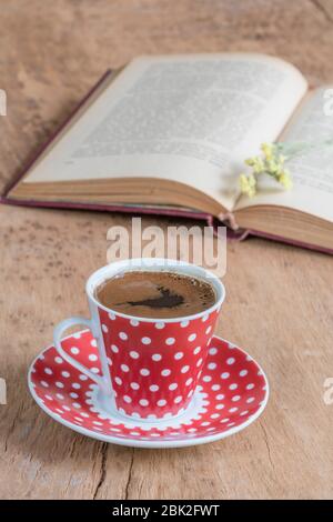 an opened old book and cup of coffee on a wooden table with copy space Stock Photo