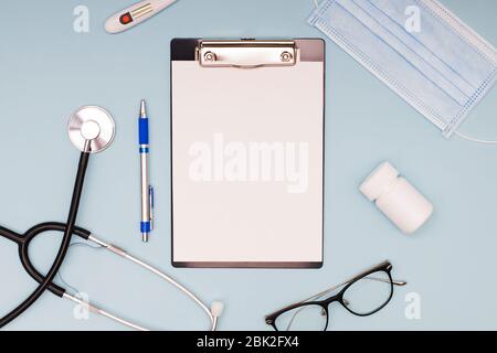 Flat lay with stethoscope, medical mask, glasses and other objects Stock Photo