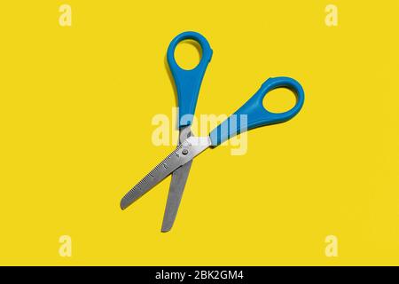 scissors on a yellow surface Stock Photo