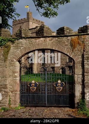 Gateway & wall to the fortified Close of Brecon Cathedral, Powys, Wales, UK, looking NE from Priory Hill. The iron gates bear ecclesiastical arms. Stock Photo