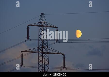 moon rising by high voltage giant electricity pylon york yorkshire united kingdom Stock Photo