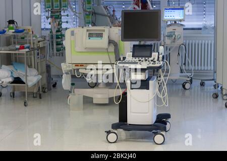 Ultrasound machine, on background patient connected to medical ventilator and dialysis machine . Place where can be treated patients with pneumonia ca Stock Photo