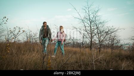 Cheerful Man And Woman Walk Outdors Holding Hands Stock Photo