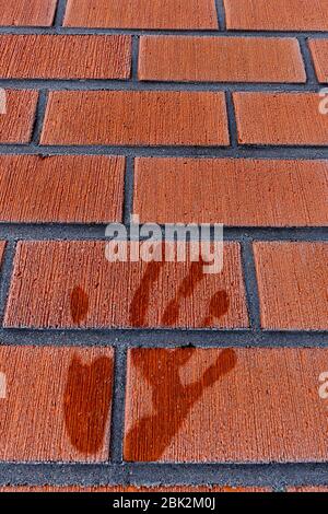 Wet melted palm print on frosty red tile wall at Winter , Finland Stock Photo