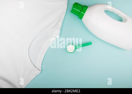 Clean white t-shirt, powder washing detergent and plastic bottle of liquid on pink background Stock Photo