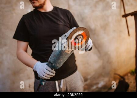 A young caucasian man holds a grinder in his hand Stock Photo