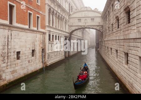 Venice, Italy; january/29/2018: Bridge of Sighs in Venice. A gondola with occupants circulating in the canal, a day of winter fog Stock Photo