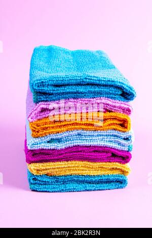 Multi-colored towels on a pink background. Pink, beige, yellow, orange and blue towels. House order Stock Photo