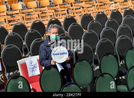 Oberwiesenthal, Germany. 01st May, 2020. Jens Weißflog, ski jumping world champion, Olympic champion and hotelier, takes part in the nationwide 'Empty Chairs' campaign of restaurateurs and hoteliers in Oberwiesenthal and holds a plate with the inscription '#restart Gastro'. Altogether, entrepreneurs with more than 900 chairs took part in the protest in the Erzgebirge. The restaurateurs demand massive support from the federal and state governments. Hotels and restaurants are currently closed due to the Corona crisis. Credit: Hendrik Schmidt/dpa-Zentralbild/ZB/dpa/Alamy Live News Stock Photo