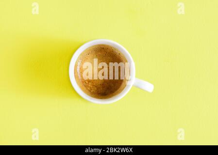 Cup of coffee espresso on yellow background with free text space. Top view, flat lay Stock Photo