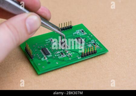The process of replacing electronic components on the motherboard with a home appliance repair technician Stock Photo