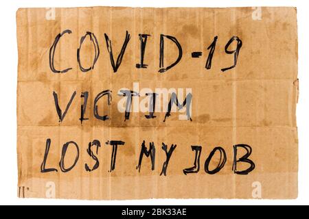 the words covid-19 victim lost my job handwritten on rectangular flat dirty sheet of cardboard - homeless placard, isolated on white Stock Photo