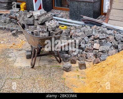 Wheelbarrow with paving stones road construction Stock Photo