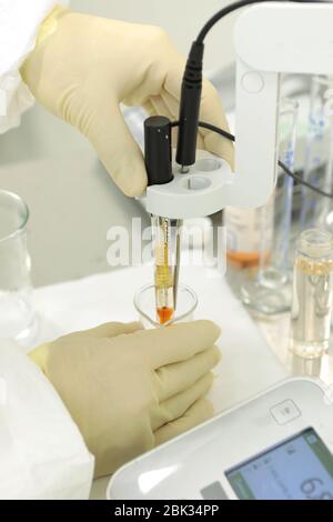 A chemist conducts a study of the stiffness of the solution. Laboratory PH measurement. A device for measuring PH chemically. Modern equipment for Stock Photo